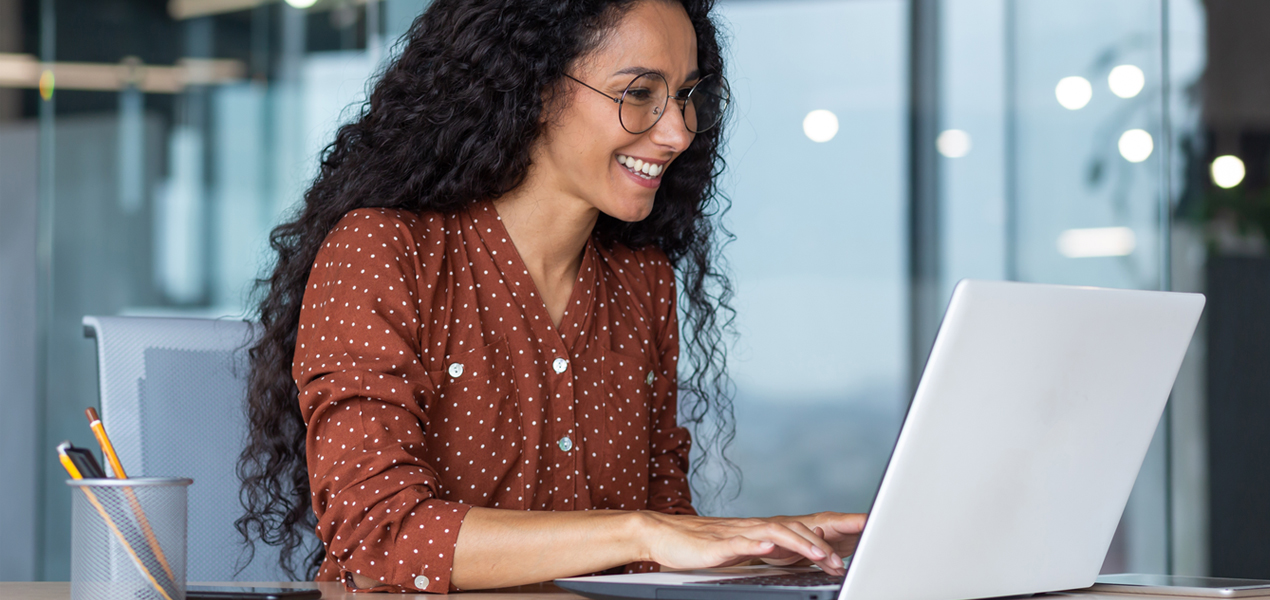 A Hispanic woman working in a modern office setting.