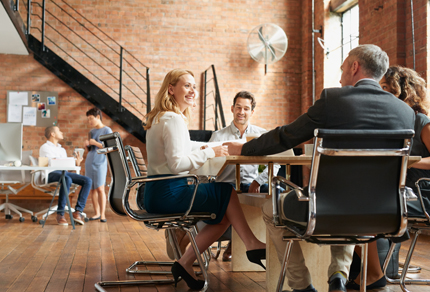 Group of people sitting around a meeting table.