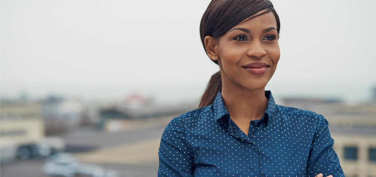 Portrait of a confident black women in a button-up shirt.